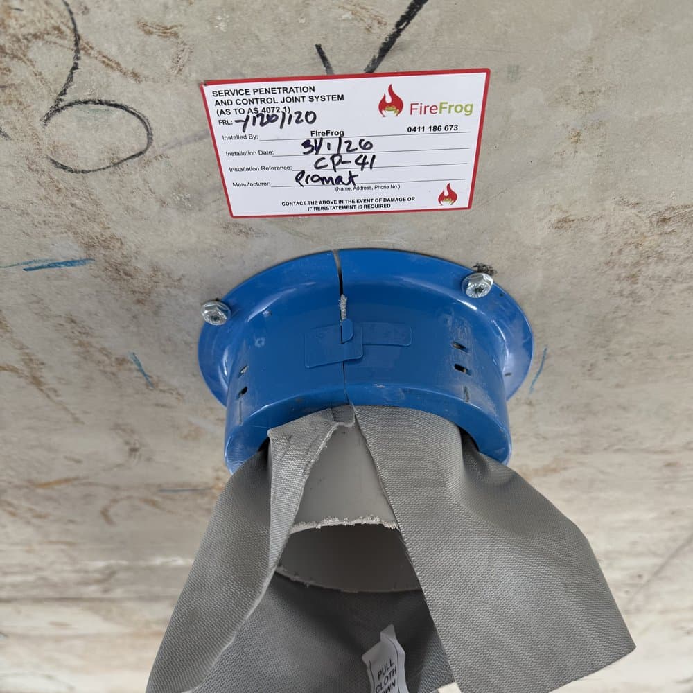 A fire collar on a plastic pipe penetration with the wrap cloth open.