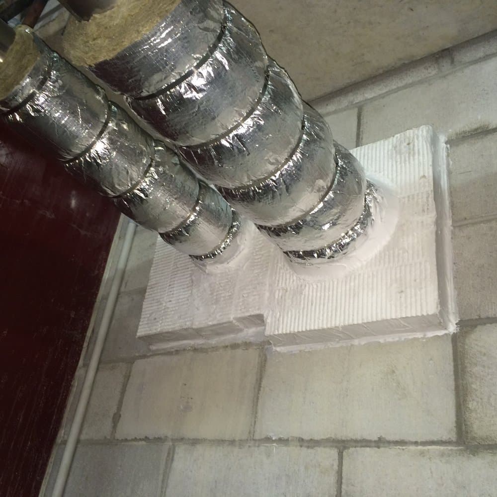 Services sealed through a fire-rated block wall with coated batt.